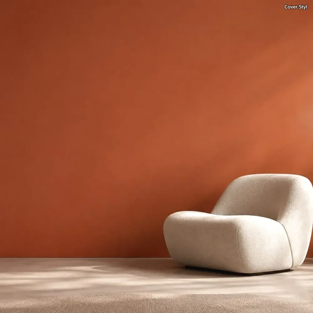 Terrakottafarbene Wand mit Cover Styl Unifolie und hellem Sessel