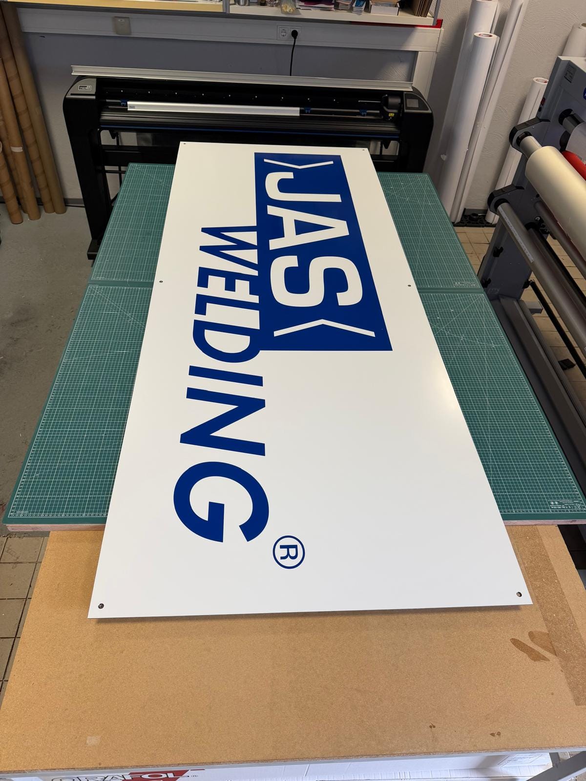 Das fertige Schild auf dem Arbeitstisch vor dem Schneideplotter in der Werkstatt
